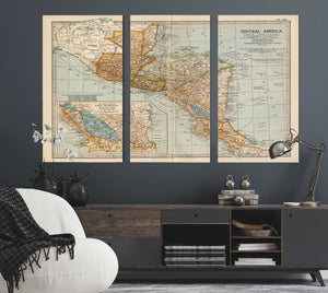 a living room with a couch and two maps on the wall