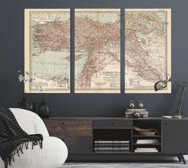 a living room with a couch and two maps on the wall