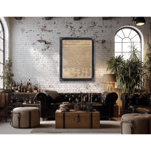 a cozy living room with a brick wall, a large window, and a framed document hanging on the wall. The room is furnished with a leather sofa, a wooden coffee table, and a potted plant. There are several bottles and a lamp in the room, adding to the rustic and vintage atmosphere.