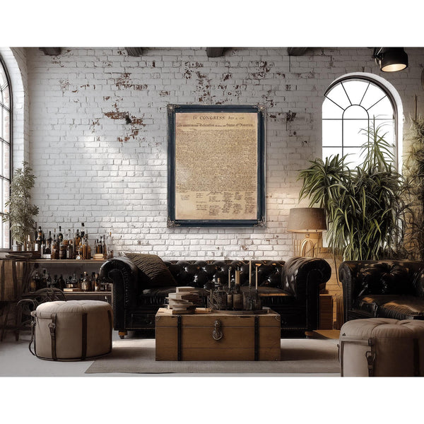 a cozy living room with a brick wall, a large window, and a framed document hanging on the wall. The room is furnished with a leather sofa, a wooden coffee table, and a potted plant. There are several bottles and a lamp in the room, adding to the rustic and vintage atmosphere.